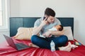 Caucasian father dad with newborn mixed race Asian Chinese baby working from home Royalty Free Stock Photo