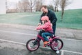 Caucasian father dad training helping girl daughter to ride bicycle. Royalty Free Stock Photo