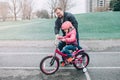 Caucasian father dad training helping girl daughter to ride bicycle. Royalty Free Stock Photo