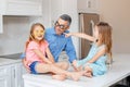 Caucasian father dad with two children daughters wearing funny glasses and laughing at each other