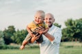 Caucasian father hugging playing with toddler baby boy. Parent holding carrying lifting child son on arms.