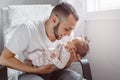 Young Caucasian bearded father dad holding newborn baby son daughter