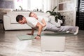 Caucasian father and small daughter in casual clothes do pushup pressup exercise on carpet on warm floor in living room, sporty