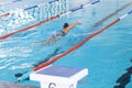 Caucasian female athlete swimmer swimming in a pool at a sports center