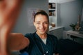 Caucasian female doctor taking selfie in doctors office with cellular device Royalty Free Stock Photo