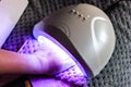 Caucasian female does self nail polish drying by using UV LED technique Royalty Free Stock Photo