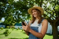 Caucasian female farmer smiling while texting on cellular device Royalty Free Stock Photo