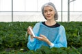 Caucasian female fruit researcher in isolation gown and disposable polyester synthetic fiber Hairnet holding Urea in PET preform