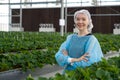 Caucasian female fruit researcher in isolation gown and disposable polyester synthetic fiber hairnet stand with arms crossed with