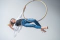 Caucasian female gymnast doing aerial hoop exercises and using smartphone. Royalty Free Stock Photo