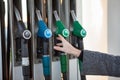 Caucasian female hand stretching to fuel nozzle with regular unleaded petrol, close up view Royalty Free Stock Photo