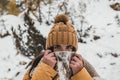 Caucasian female hiker wearing winter clothes and a backpack walking on a snowy path in the forest Royalty Free Stock Photo