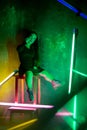 Caucasian female inclusive model posing on studio background in neon light