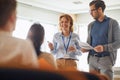 Caucasian female lecturer standing with beardy male wearing glasses