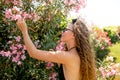 Young woman posing in swimming suite against bushes with pink roses. Royalty Free Stock Photo