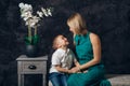 Caucasian female parent and son prescholler boy sitting together on couch indoors. Happy mother day holiday Royalty Free Stock Photo
