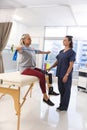 Caucasian female physiotherapist and senior woman with artificial leg using exercise band stretching Royalty Free Stock Photo