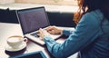 Caucasian female programmer sitting at desk with coffee, using laptop with coding on screen Royalty Free Stock Photo
