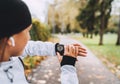 Caucasian female runner checking fitness progress on her smart watch. Woman monitoring a heart rate on her watch outdoors. .