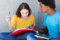 Caucasian female student learning with african american male stu Royalty Free Stock Photo