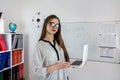 Caucasian female student standing near whiteboard explains the rules in classroom Royalty Free Stock Photo