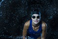 Watersports Concepts. Sportive Caucasian Female Swimmer in Swimsuit Posing in Goggles in Aqua Studio With Multiple Water Droplets Royalty Free Stock Photo