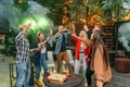 Caucasian friends having garden party outside, they dancing to the Dj`s music with bengal lights in house backyard at