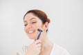 Caucasian funny woman shaves her face with a straight razor on a white background. Copy space. Royalty Free Stock Photo