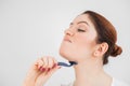 Caucasian funny woman shaves her face with a straight razor on a white background. Copy space. Royalty Free Stock Photo