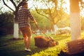 Caucasian Gardener working with lawnmower and cutting grass during summer season Royalty Free Stock Photo