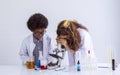 Caucasian girl and African black boy studying Science and doing experiment together in classroom at school. Education and Royalty Free Stock Photo