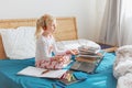 Caucasian girl child meditating in bed and learning online on laptop Internet. Virtual class lesson on video during home self