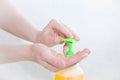 Caucasian girl clicks dispenser with soap. Close-up, white background