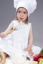 Caucasian Girl In Cook Uniform Making a Mix of Flour, Eggs and Vegetables Royalty Free Stock Photo