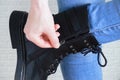 Caucasian girl hand unzips on black boots Royalty Free Stock Photo