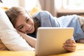 Caucasian girl having video chat with friends using tablet camera while lying on bed - technology, communication concept Royalty Free Stock Photo