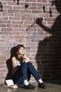 Caucasian girl sitting on the floor reading a horror or scary thriller book. Dramatic lighting with girls eyes wide open Royalty Free Stock Photo