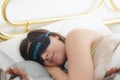 Caucasian girl sleeping in the bed with a mask on her eyes and t