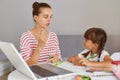 Caucasian girl studying with mother or teacher at study table with laptop computer, books and having fun learning, mommy explain Royalty Free Stock Photo