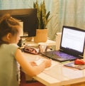 Caucasian girl using home computer and writing her homework. Homeschooling, study online
