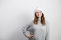 Caucasian girl wearing sweater and Santa hat smiling standing over gray wall. Copy space. Christmas and New year concept. Royalty Free Stock Photo
