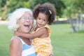 Caucasian grandma carrying her hispanic granddaughter Royalty Free Stock Photo