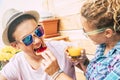 Caucasian guy and adult woman at home in the terrace having breakfast together with a funny face of the teenager whil he`s eating