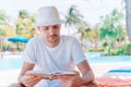 Caucasian guy relaxing near pool with amazing view and reading book Royalty Free Stock Photo