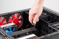 caucasian hand connecting or disconnecting power connector of GPU card in opened black miditower PC case