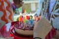 Caucasian hands lighting candles on a birthday cake