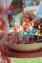 Caucasian hands lighting candles on a birthday cake