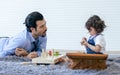 Caucasian handsome beard father or daddy wearing shirt with necktie, lying down on the floor, taking care and playing toys with Royalty Free Stock Photo