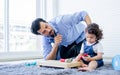 Caucasian handsome father taking care, playing toys with his little cute daughter on floor in cozy living room at home after work Royalty Free Stock Photo