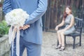 Caucasian handsome man giving flowers to asian girlfriend asking for proposing to marry him at green park. Couple lover on Royalty Free Stock Photo